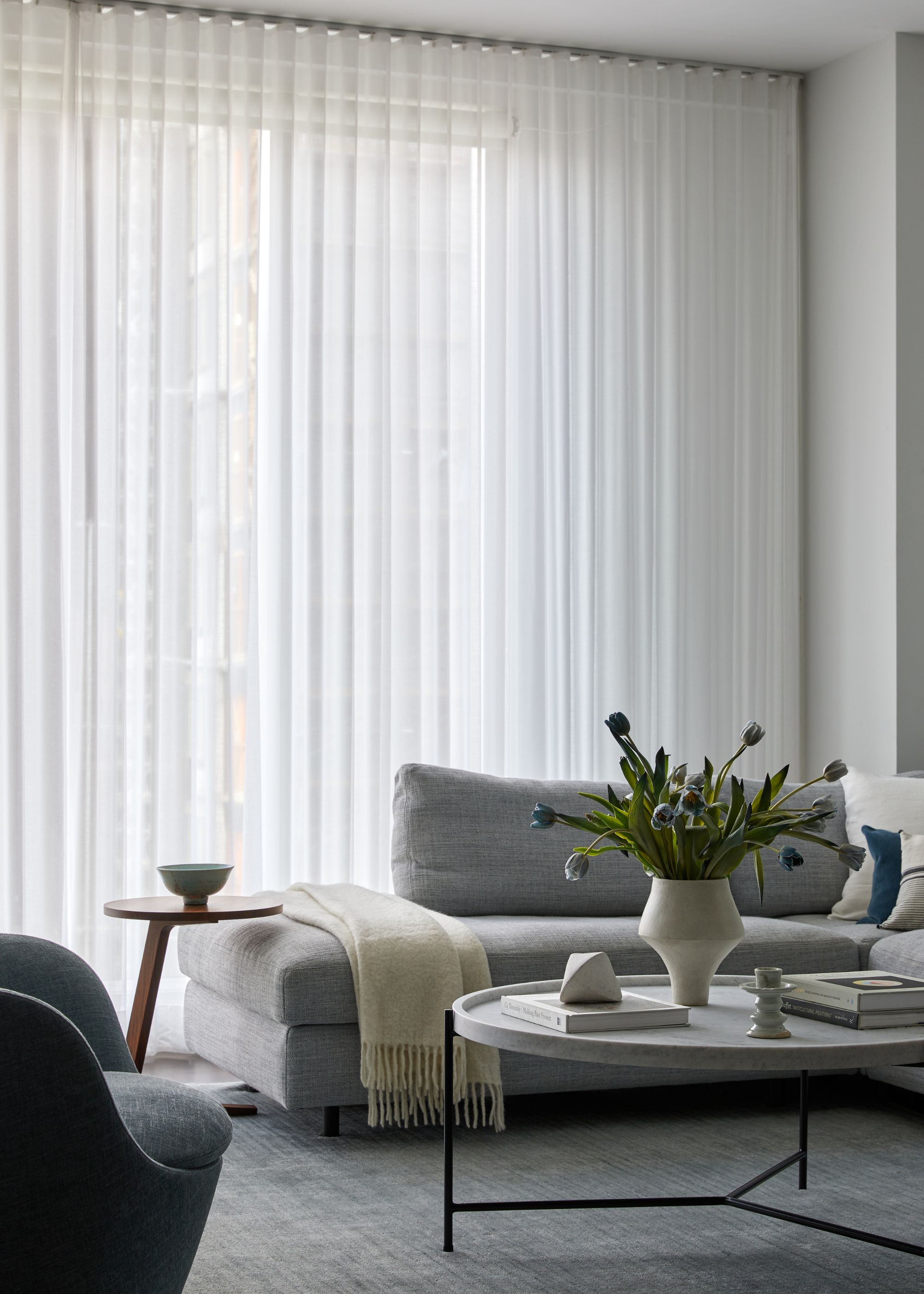 minimal living room with sheer full-length curtains and gray sofa