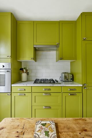 Green kitchen in colorful London apartment