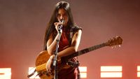 Nene Royal singing and playing guitar on stage 