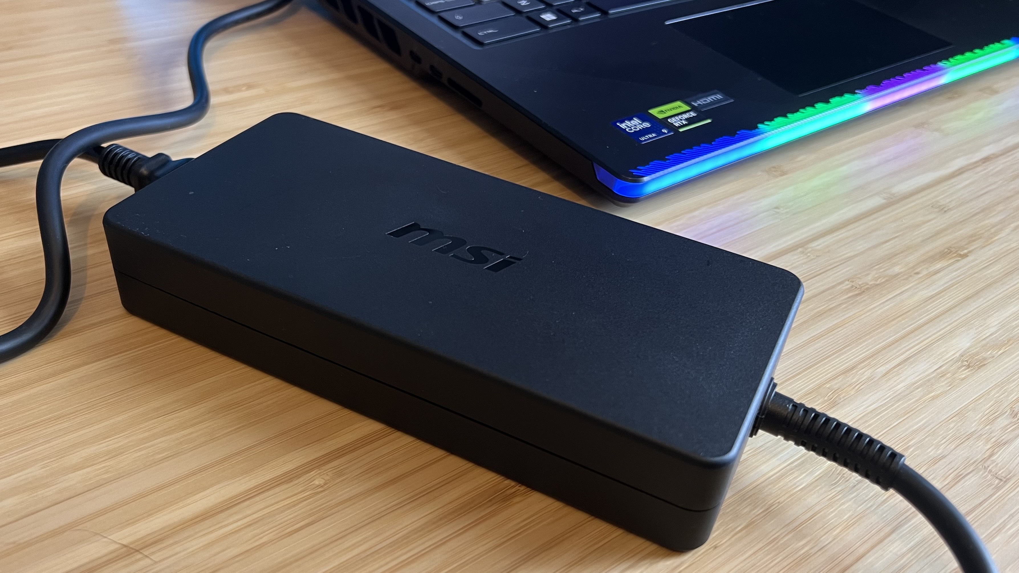 MSI Raider 16 Max power adapter on a wooden desk
