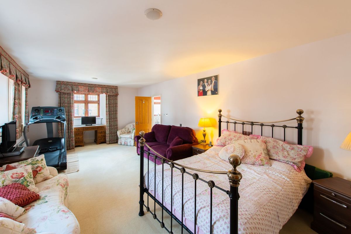 Bedroom with white carpet and white sheets on the bed