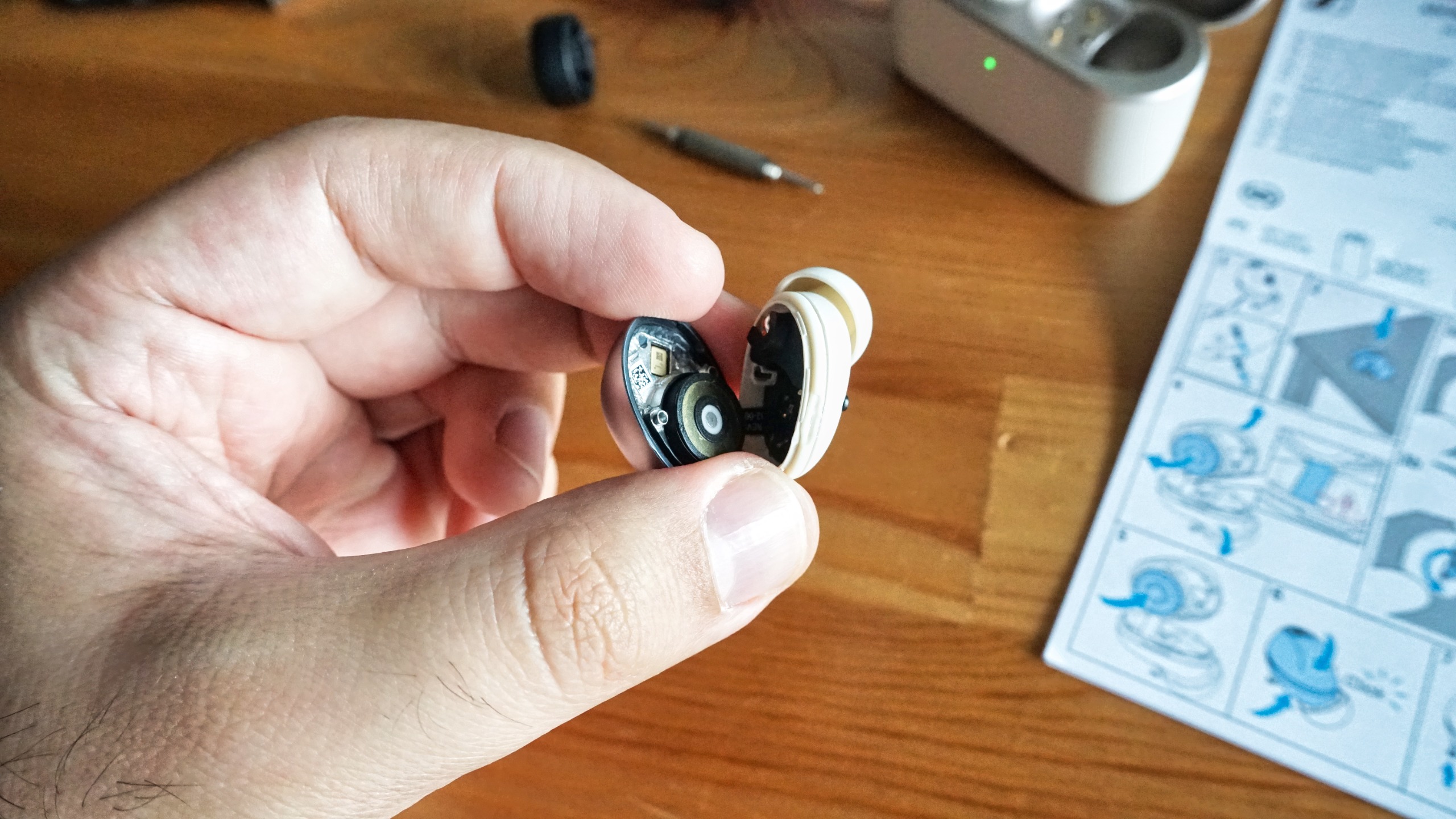 Sennheiser Momentum True Wireless 5 in white, showing details of the buds held in a hand