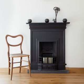 room with fire stove white wall and wooden flooring