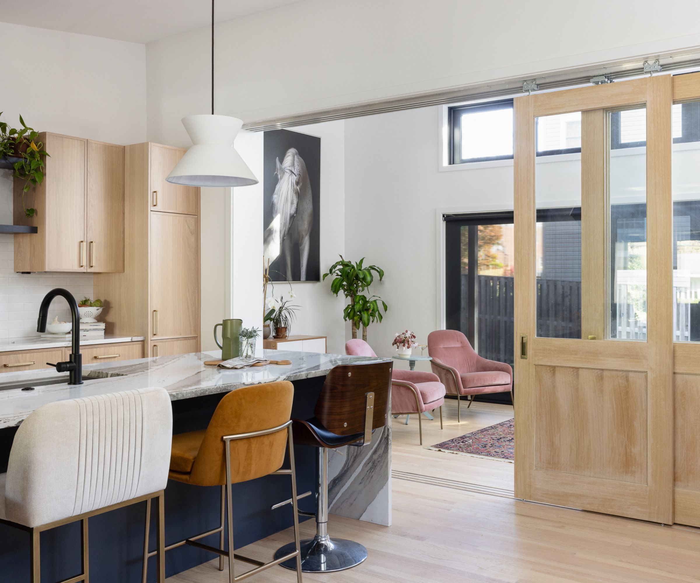 A large kitchen with island seating and a connected living area