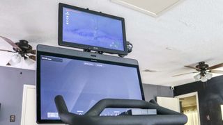 A picture of the Peloton Bike Plus with a portable monitor mounted above it
