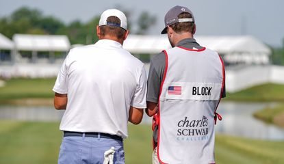 Block speaks to his caddie with their backs to the camera 