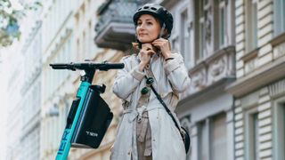 Person putting on a helmet on an Electric scooter