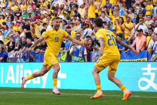 Denis Dragus of Romania celebrates with teammate Dennis Man after scoring his team's third goal during the UEFA EURO 2024 group stage match between Romania and Ukraine at Munich Football Arena on June 17, 2024 in Munich, Germany.