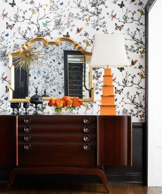 Sideboard with patterned wallpaper behind it