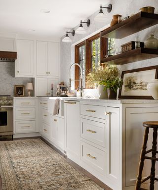 transitional kitchen with white cabinets, dark wood shelves, beige patterned rug