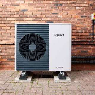 air source heat pump in front of brick wall