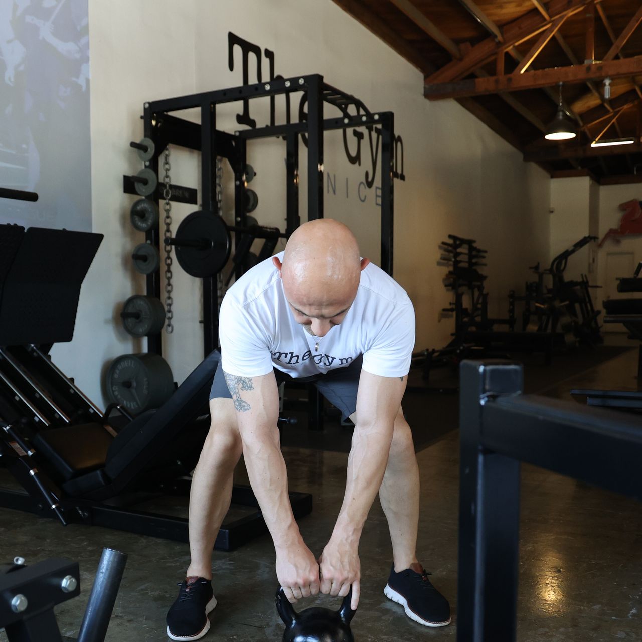 Man performing kettlebell swing exercise in gym