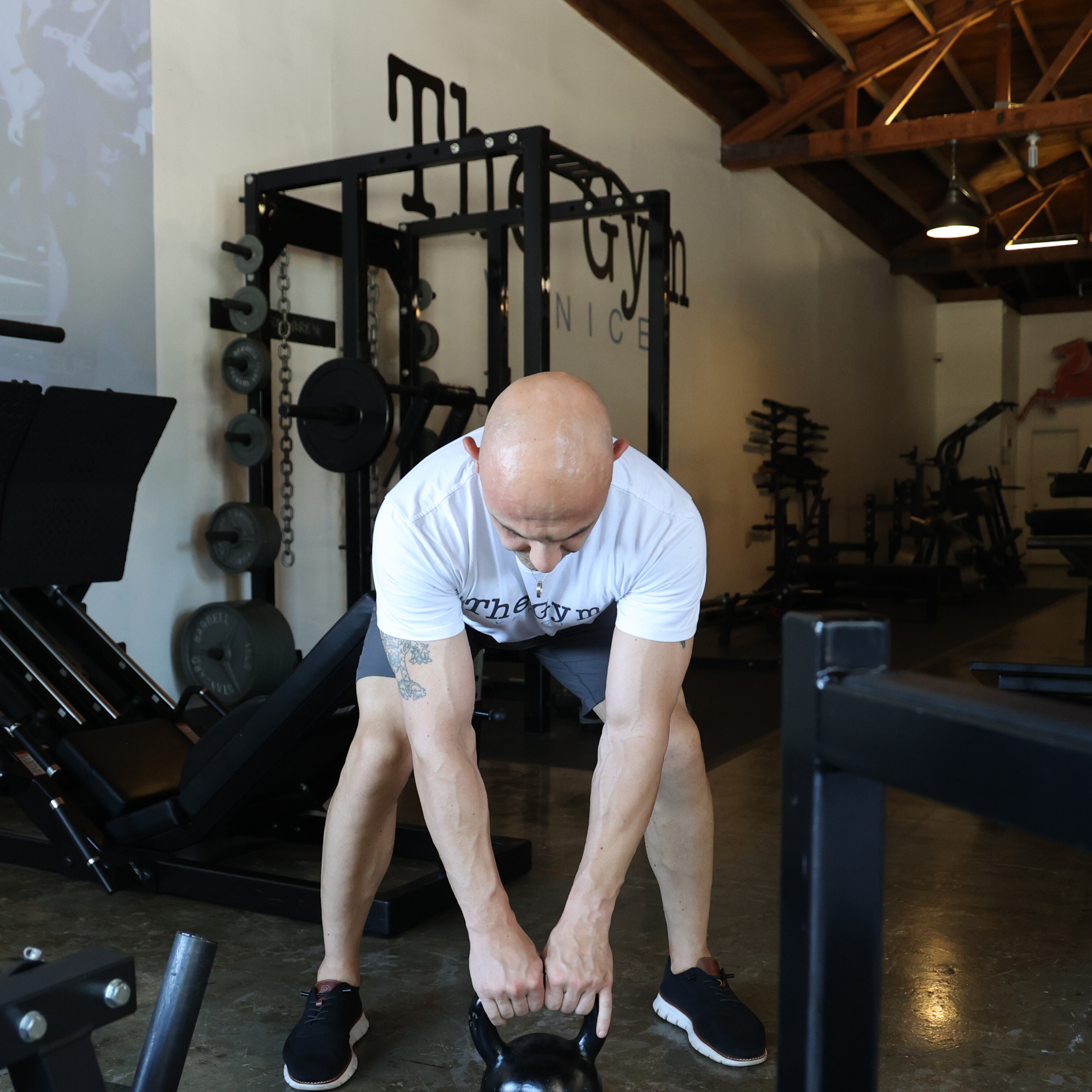 Man performing kettlebell swing exercise in gym