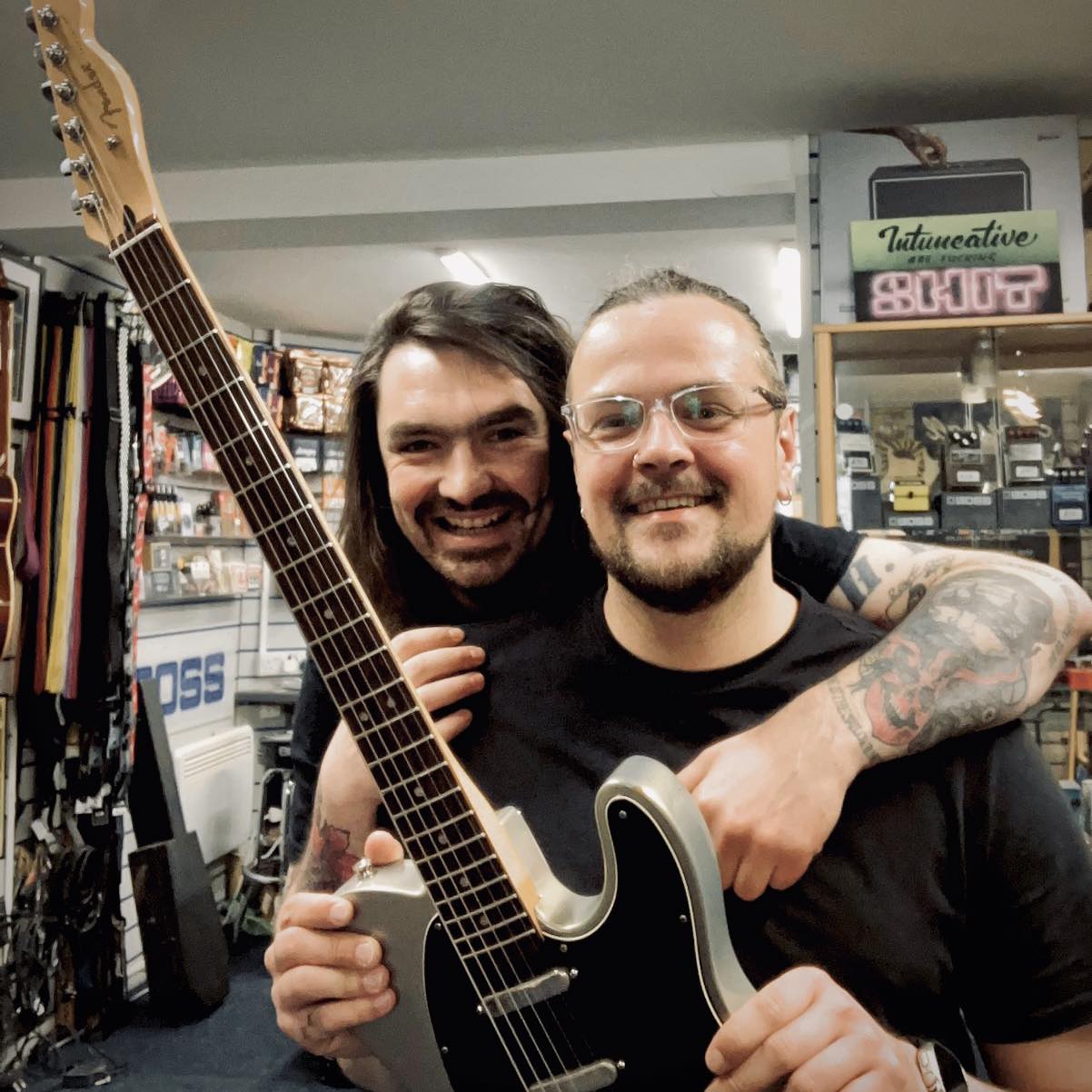 A photo of Mark Wood (right) and Sam Orr. Wood had Orr, owner of Sam's Guitars in Cheshire, England, place some of his father's ashes into the fret markers of the Fender Telecaster he's holding in this photo.