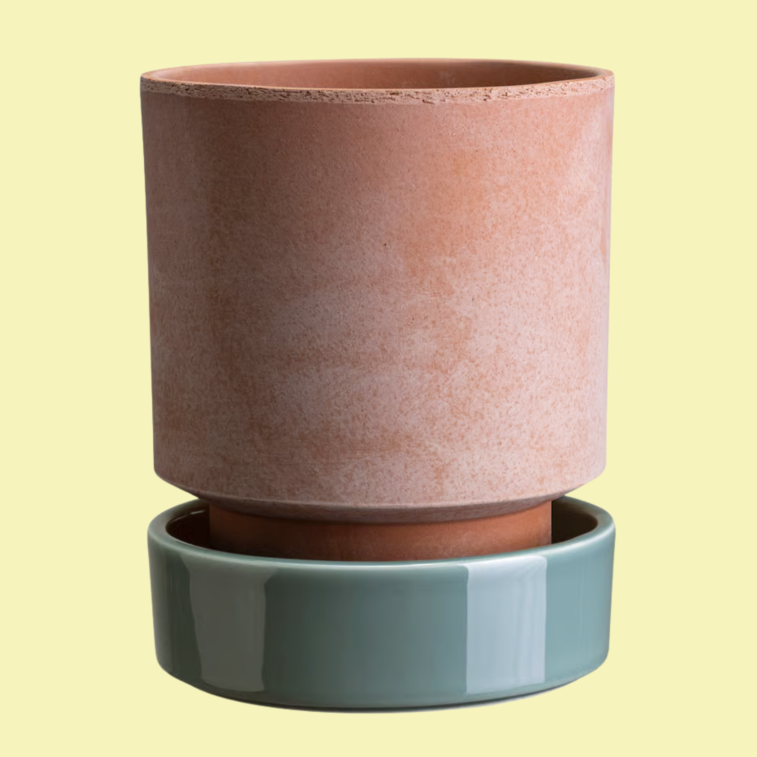 A terracotta planter with a pale blue glazed ceramic coaster