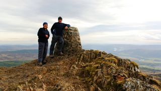 Two hikers on the summit of Ben Vrackie in Scotland