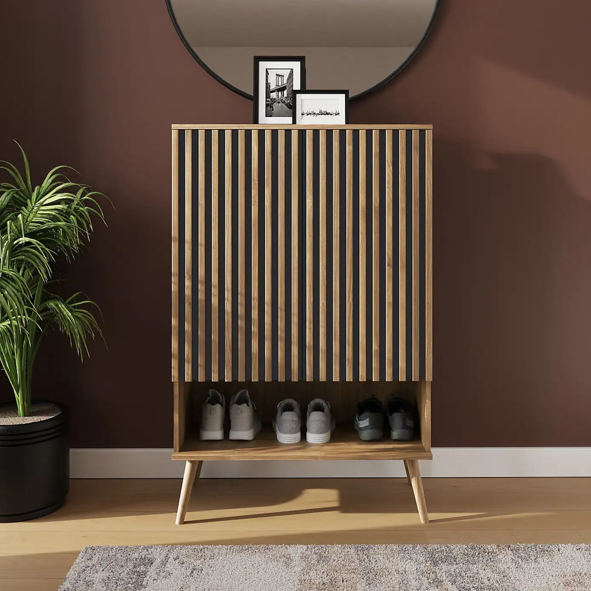 Oak shoe storage unit with slatted doors and shoes on the bottom shelf in a hallway