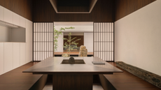 A Japanese dining room with a sunken space and sliding doors leading out into a courtyard