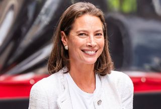 Christy Turlington at a Chanel Tribeca Film Festival lunch at Locanda Verde in NYC wearing a tweed jacket with a white T-shirt, jeans, and brown Chanel shoes.