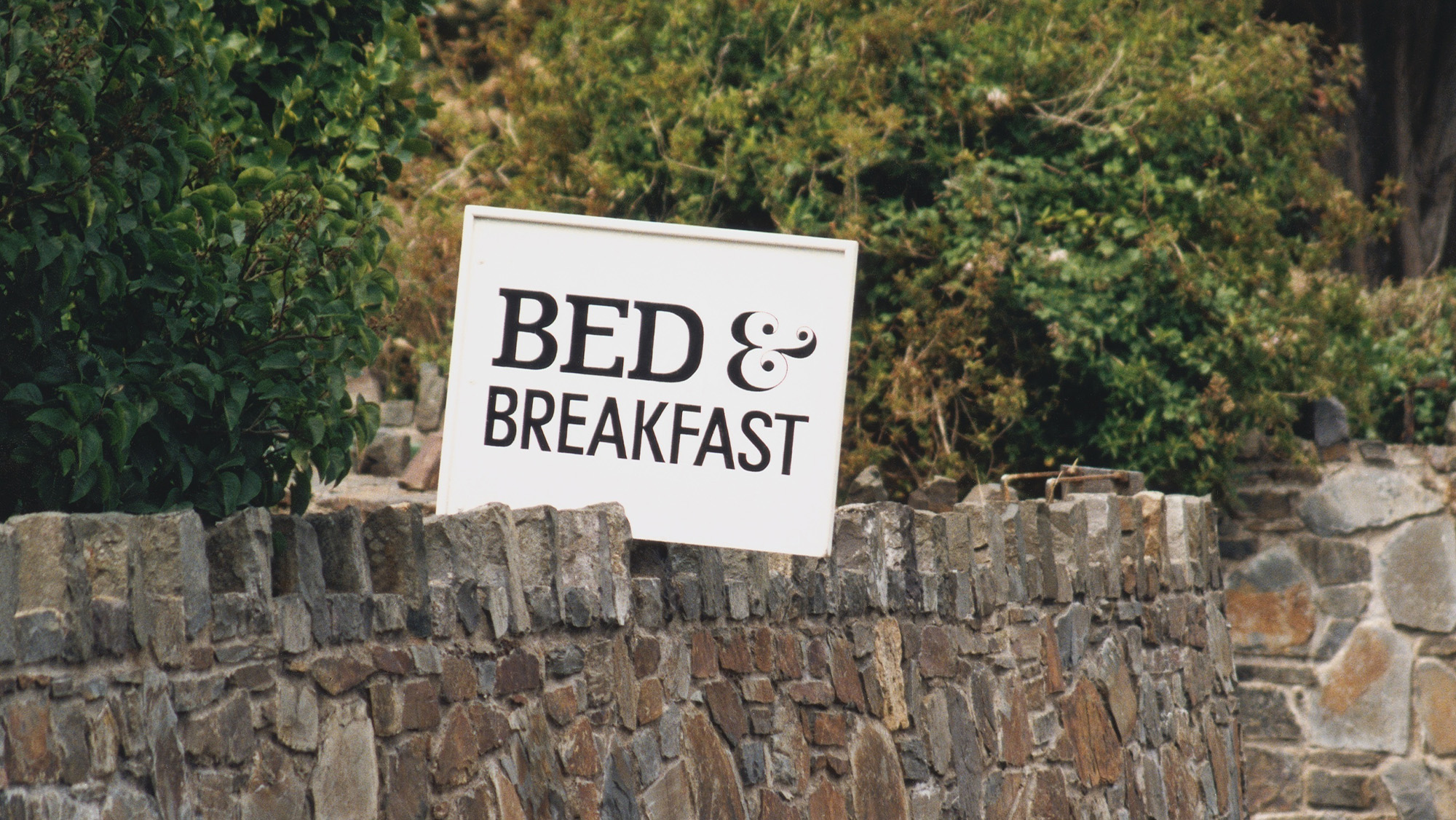 Bed &amp; Breakfast sign on stone wall