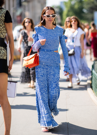 A guest wearing orange JW Anderson bag and blue dress with slit seen outside Chanel on day three during Paris Fashion Week Haute Couture FW18 on July 2, 2018 in Paris, France