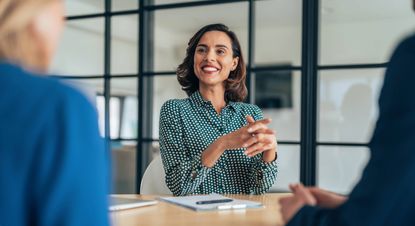 Smiling financial adviser consults with clients in a meeting room