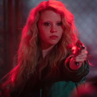 mia goth as maxine minx holding a gun in maxxxine