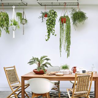white dining room with hanging pots and table