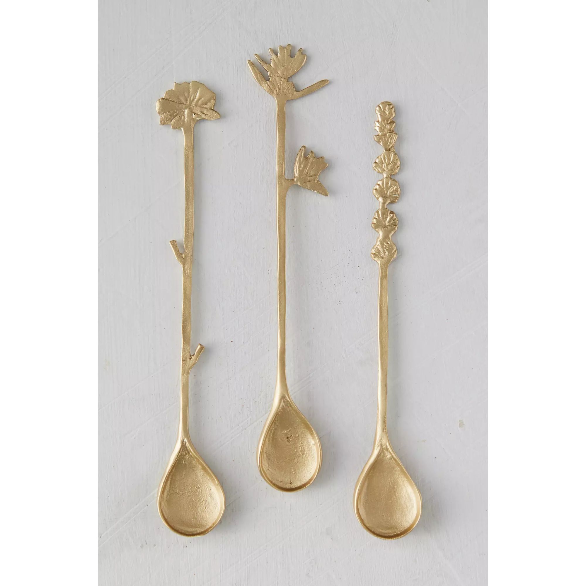 Long brass stirring spoons with floral designs