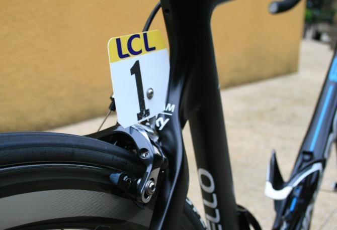 The standard approach to dossard holding: a twisted length of stainless steel clamped between brake and frame