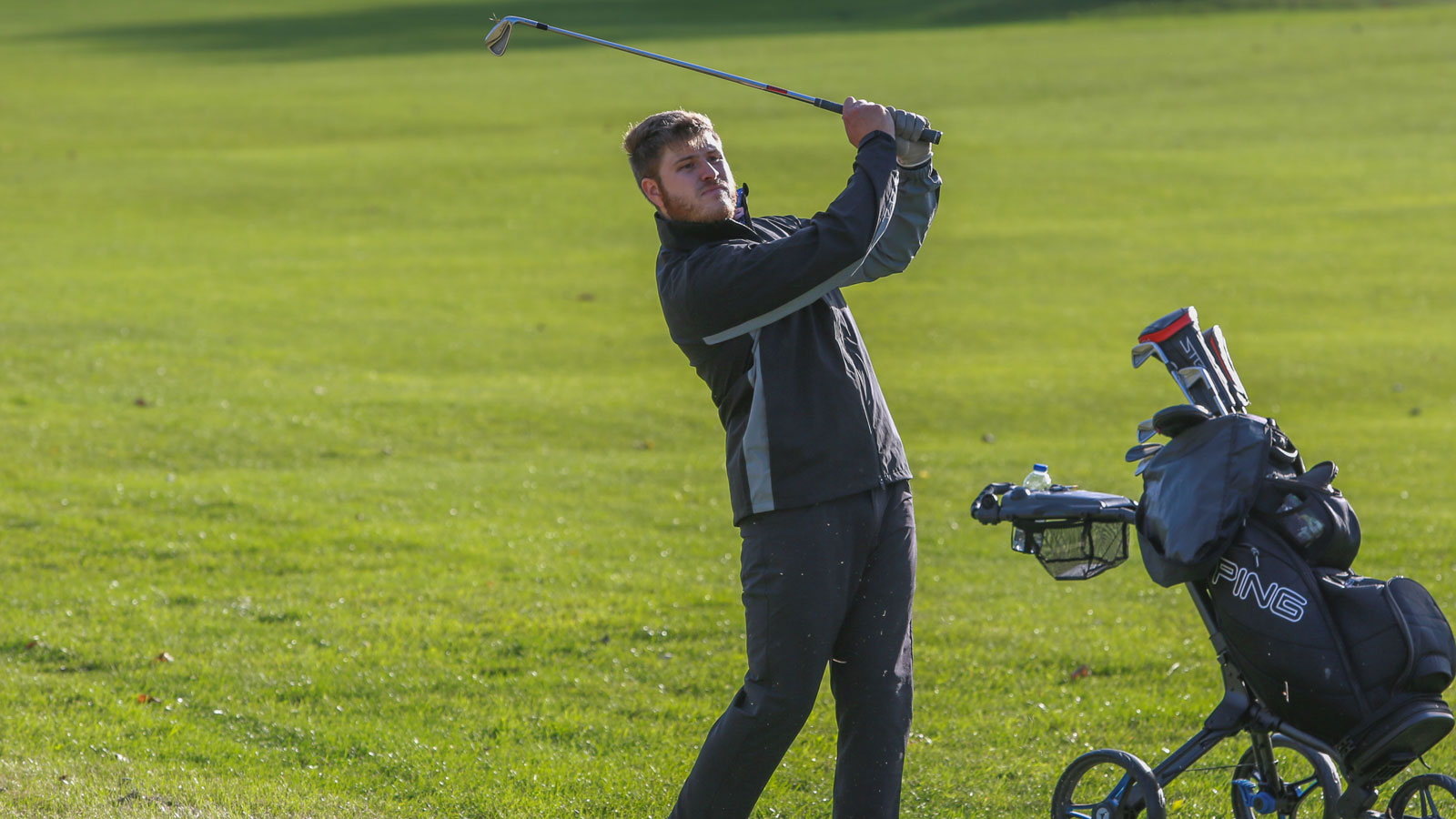 A golfer hits a shot whilst wearing a Puma Nordic DWR Golf Jacket