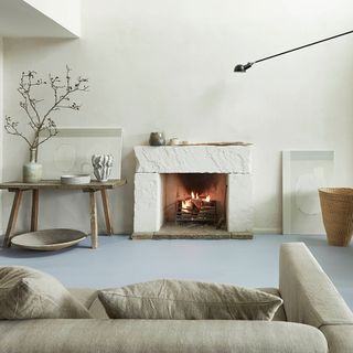 A white living room with a textured fireplace and light blue flooring