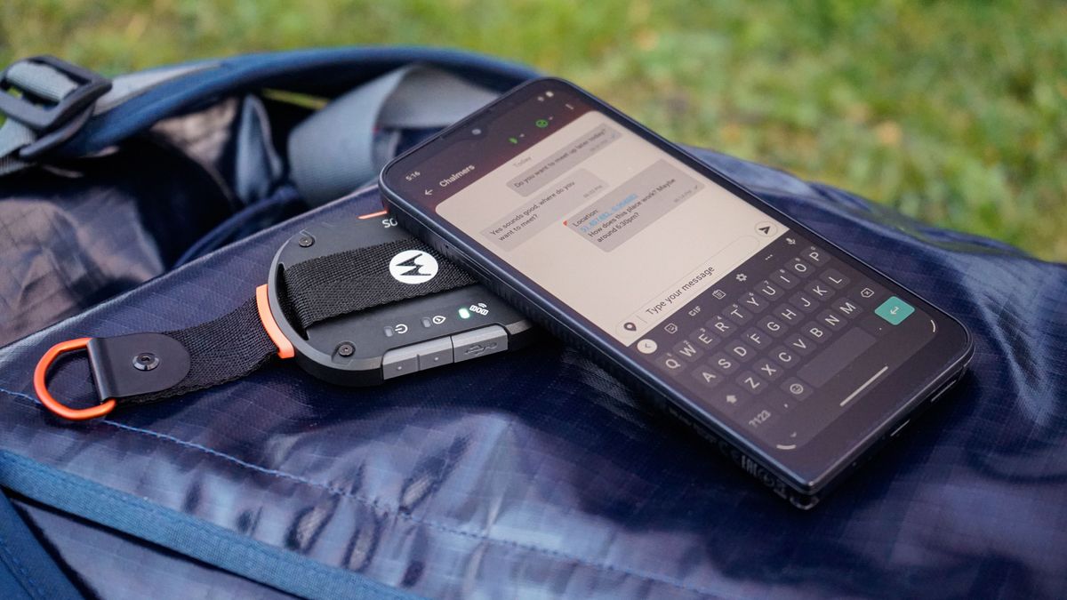 motorola defy satellite link underneath smartphone on backpack in green field