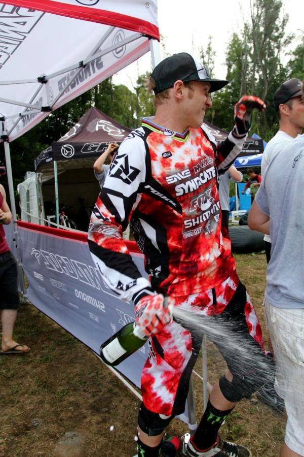 Steve Peat gets ready to soak his teammate in champagne