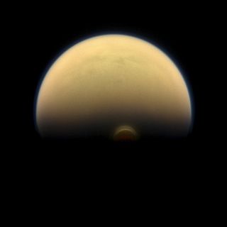 The south polar vortex at Saturn's moon Titan stands out in the dark south against the orange and blue haze layers as seen by NASA's Cassini spacecraft.