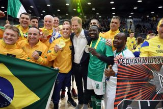 Prince Harry smiling and posing with medal winners at the Invictus Games