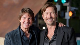 Tom Cruise and Glen Powell in suits smiling at the Digger US premiere.