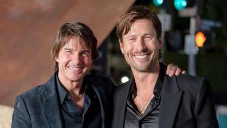 Tom Cruise and Glen Powell in suits smiling at the Digger US premiere. 