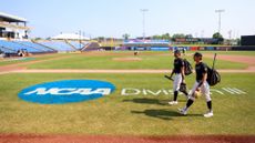 Baseball players from the University of Wisconsin-Whitewater walk along the field.