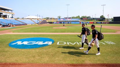 Baseball players from the University of Wisconsin-Whitewater walk along the field.