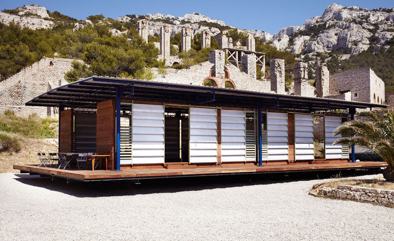 Steel frame building with wooden deck and sliding louvred doors