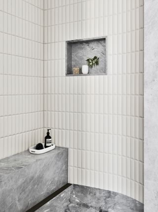a neutral bathroom with a marble niche