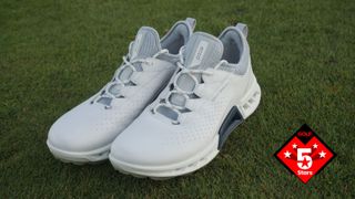 The stunning bright white Ecco Biom C4 Shoe resting on the golf course
