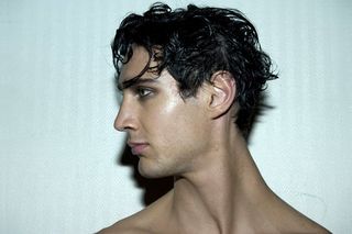 male model with dark textured hair looking to the left