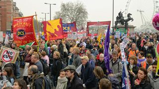 A crowd of protesters holding union banners in London