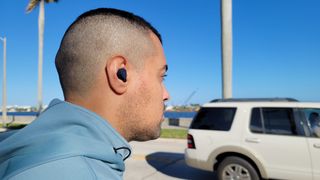Best workout headphones: The Jabra Elite 4 Active's noise cancellation being tested outside 
