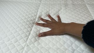 Image shows our lead reviewer placing her hand on the top of the Nectar Mattress during temperature regulation testing