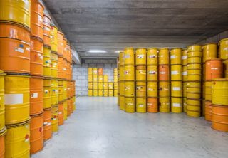 radioactive waste management site with barrels of waste pictured in a warehouse