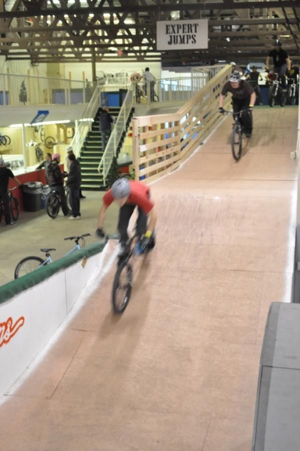 Riders go by in a blur as they build up speed to jump.