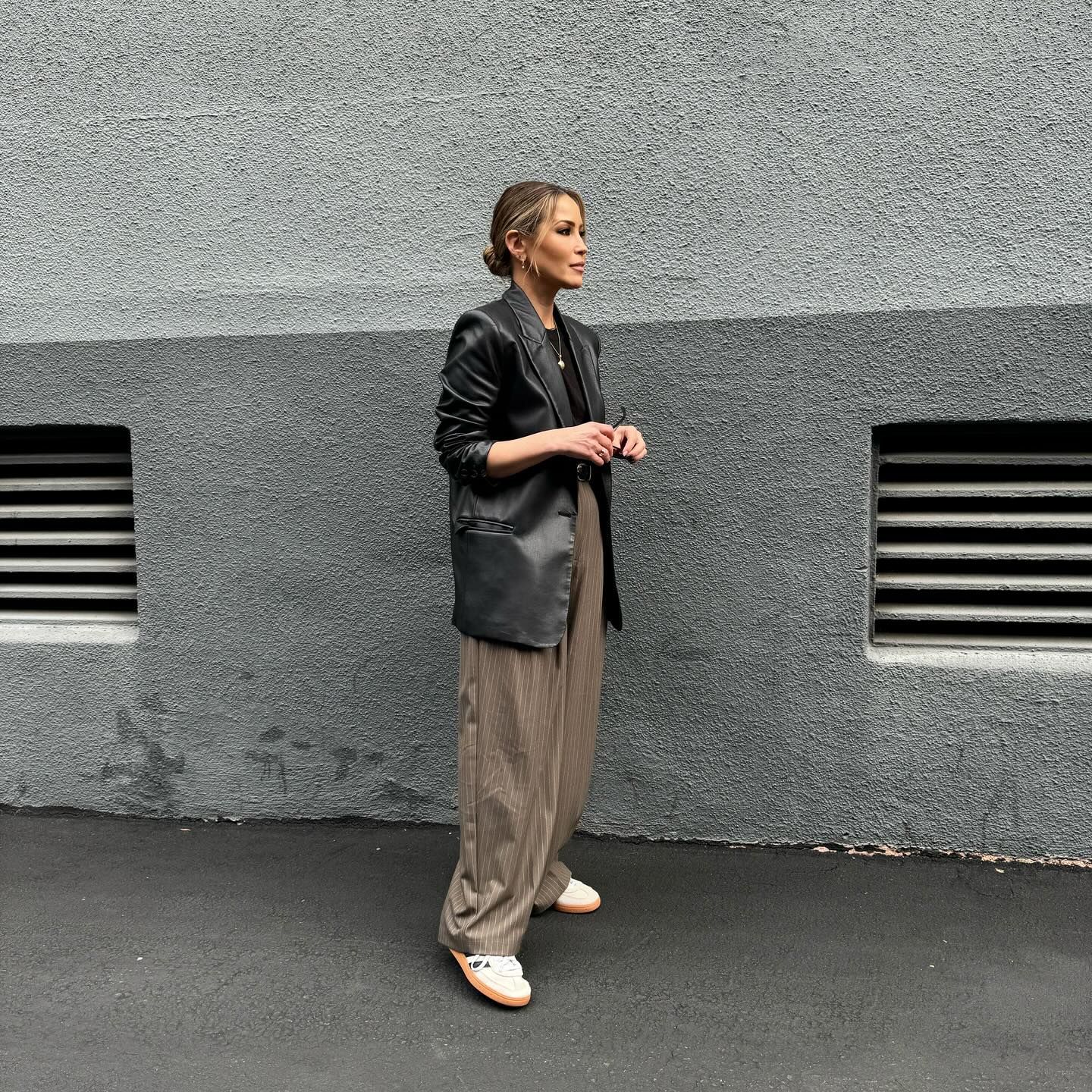 Rachel Stevens styles M&S olive green pinstripe trousers with a black leather blazer and white trainers.